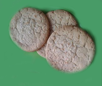 3 white choc chip cookies on green background