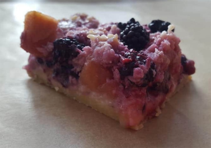 slice of a blackberry and apple pudding with a pastry base, modified from an old school dinner recipe for apple coconut squares