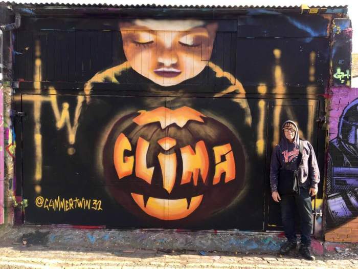 Halloween celebration street art wall painting by Glimmertwin Carved pumpkin with small child