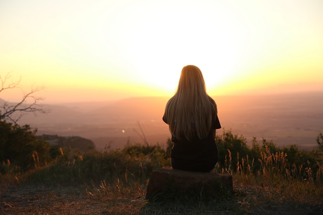girl with long blonde hair watching a sun set for a-z top tips for health and wellbeing