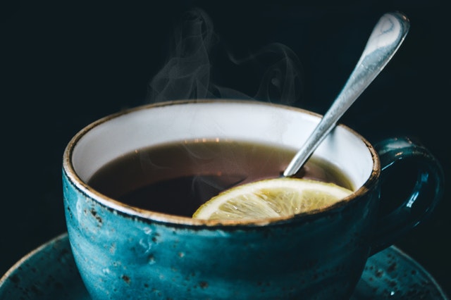 blue cup of black tea with a slice of lemon